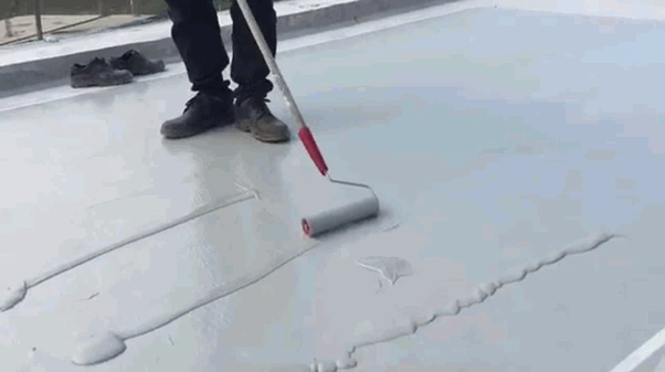 Man applying waterproofing sealant to terrace with roller.
